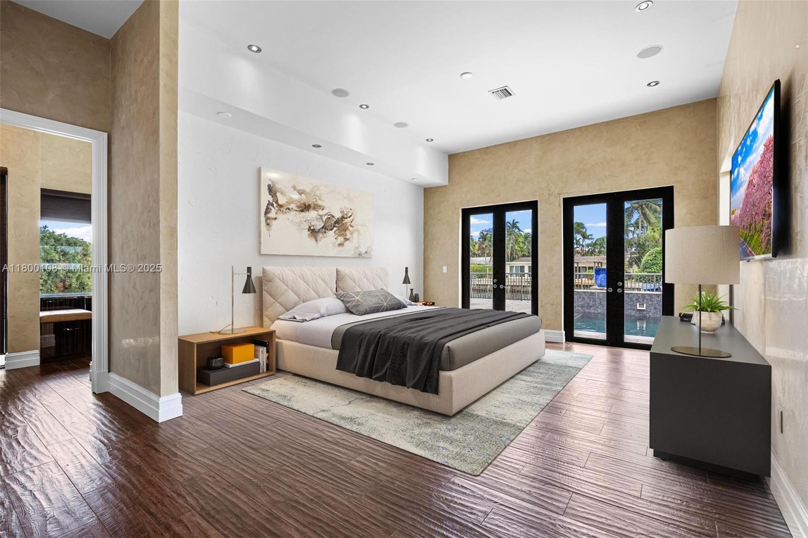 12605 Cyprus Road North Miami, FL 33181 - Photo 28 of 60 a spacious bedroom with a large bed and a wooden floor