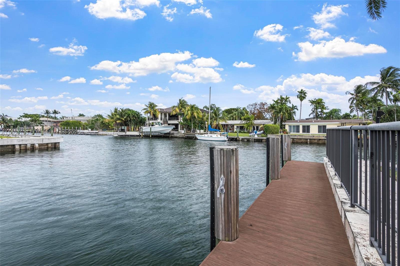 12605 Cyprus Road North Miami, FL 33181 - Photo 43 of 60 a view of a lake with boats and a large tree