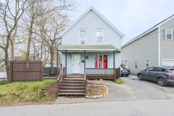 a front view of a house with a garden and parking