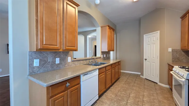 a kitchen with stainless steel appliances granite countertop a sink and a stove