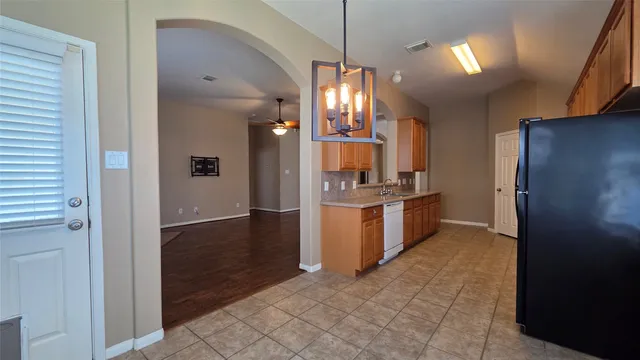a kitchen with refrigerator and cabinets