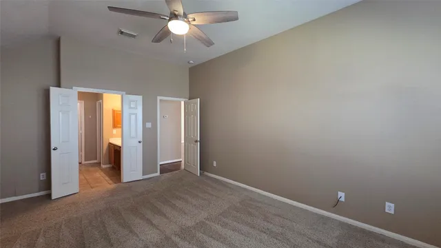 an empty room with closet and a chandelier fan