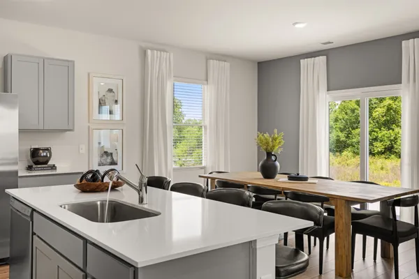 a kitchen with a dining table chairs and wooden floor