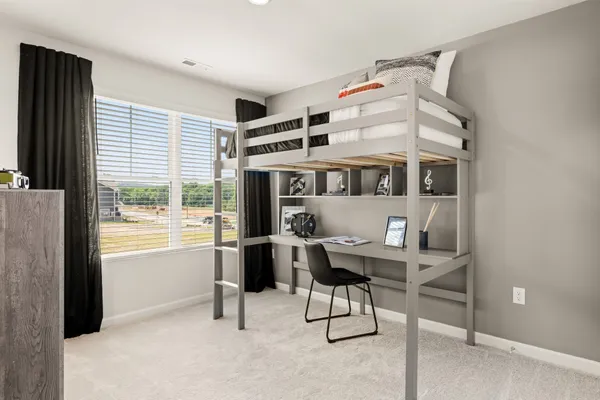 a view of a bedroom with furniture and window