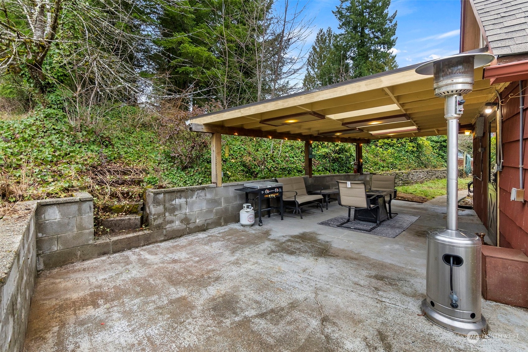 293 Logan Hill Road Chehalis, WA 98532 - Photo 23 of 36 a view of a patio with table and chairs under an umbrella with a large tree