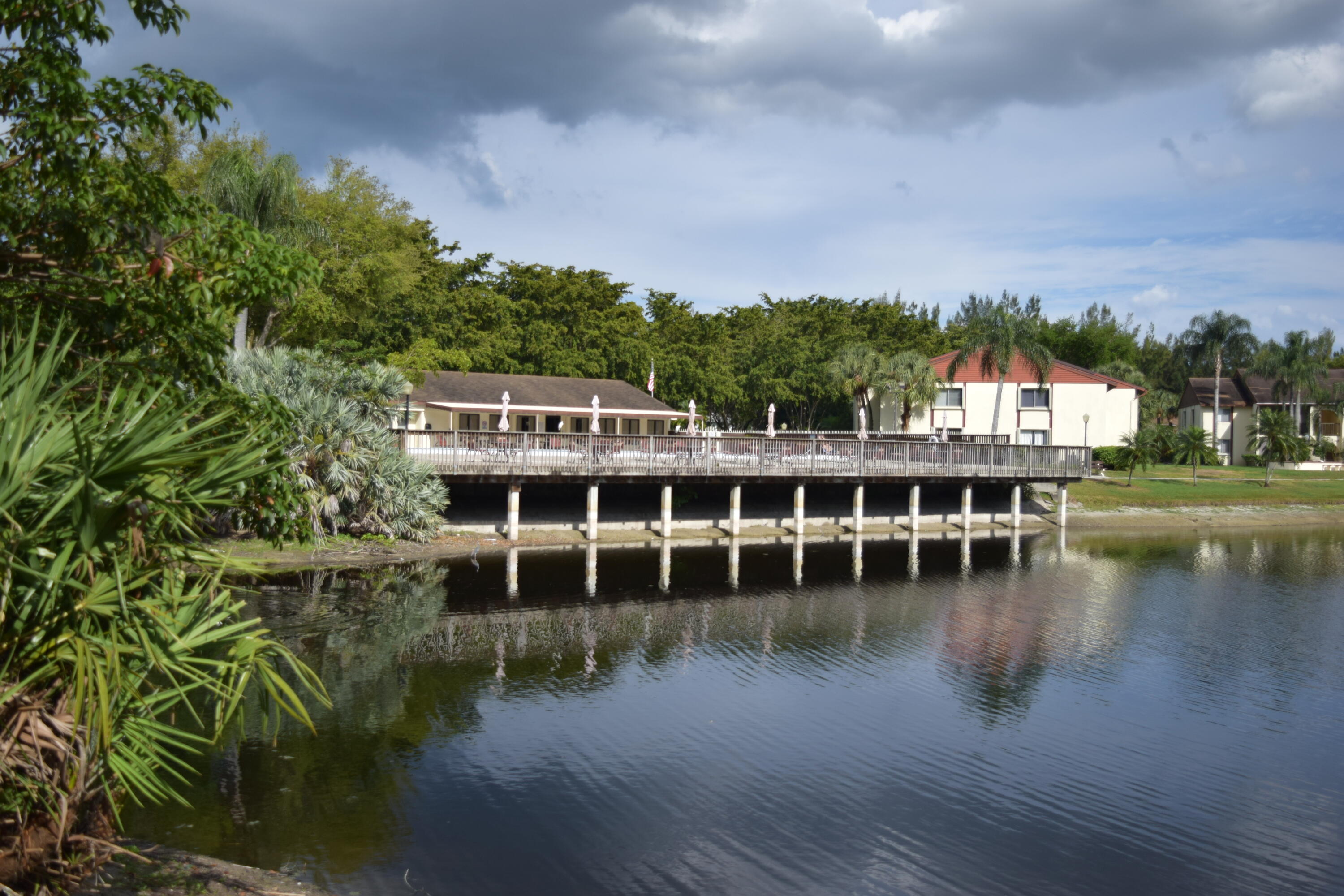 4988 Sable Pine Circle, Unit A2 West Palm Beach, FL 33417 - Photo 26 of 32 a view of a lake with a house in the background