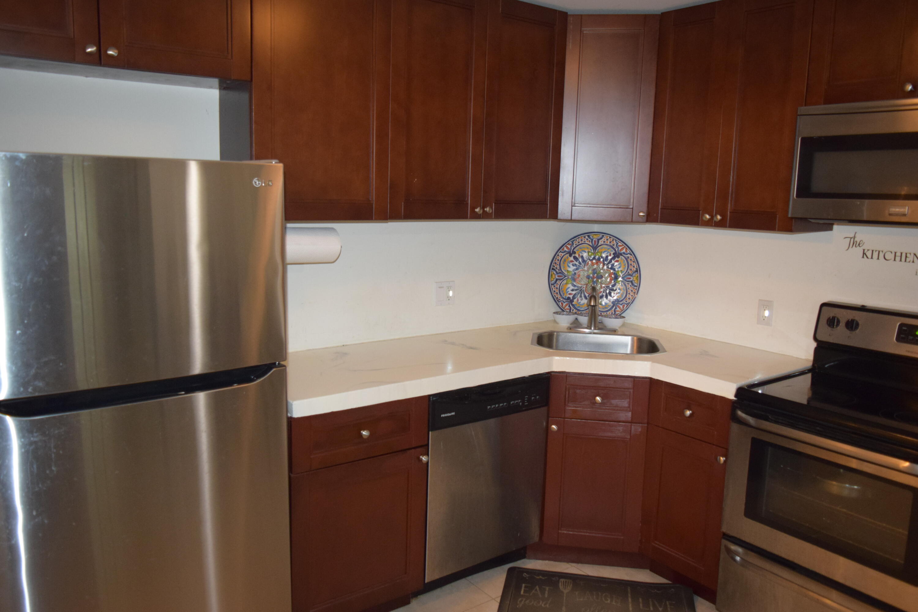 4988 Sable Pine Circle, Unit A2 West Palm Beach, FL 33417 - Photo 6 of 32 a kitchen with stainless steel appliances a refrigerator and cabinets