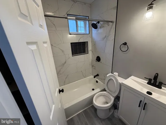 a bathroom with a granite countertop toilet sink and shower