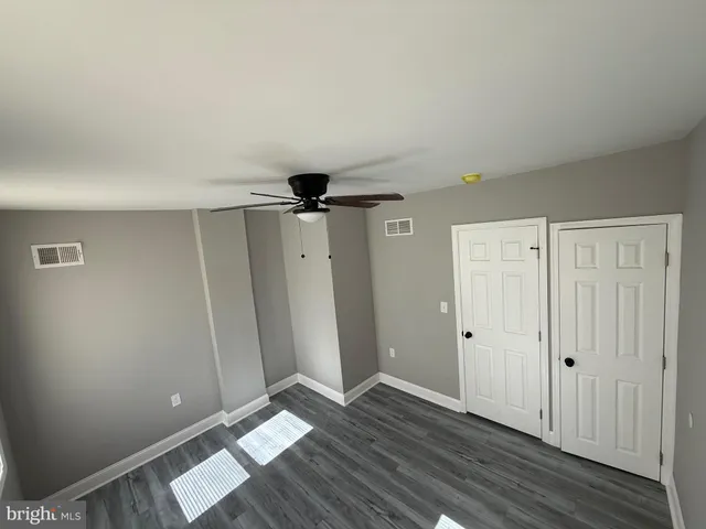 a view of an empty room and window and wooden floor