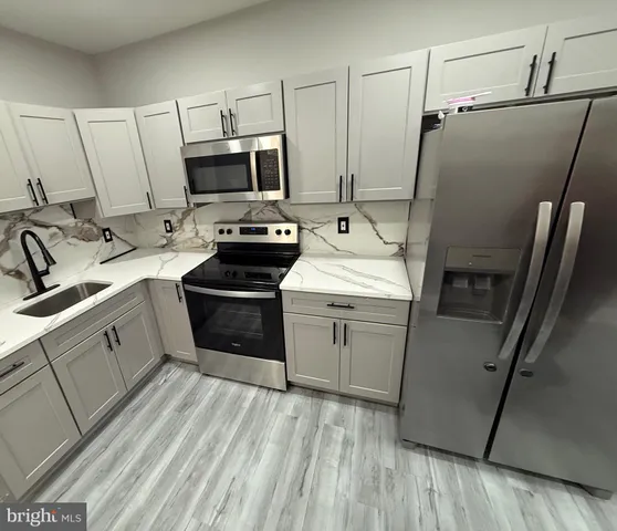 a kitchen with a sink appliances and cabinets