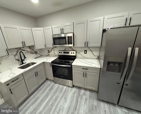 a kitchen with appliances a sink and cabinets