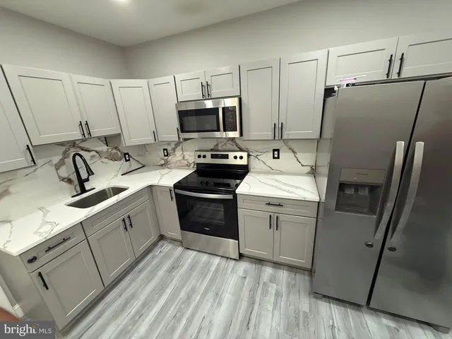 a kitchen with a sink appliances and cabinets