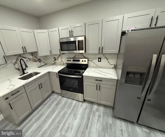 a kitchen with a sink appliances and cabinets