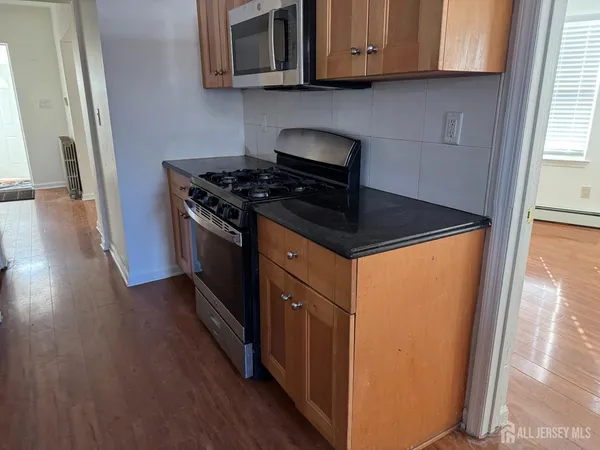 a kitchen with stainless steel appliances granite countertop a stove and a microwave