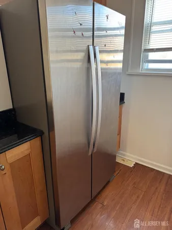 a view of a storage and utility room with wooden floor