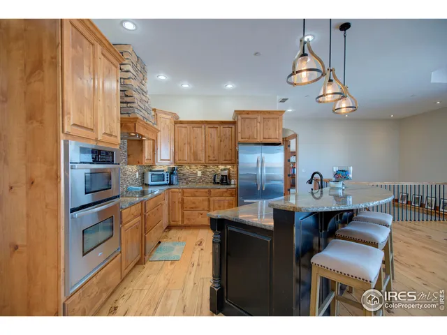 a kitchen with stainless steel appliances granite countertop a sink and a refrigerator