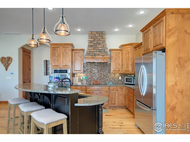 a kitchen with stainless steel appliances granite countertop a sink a stove and a refrigerator