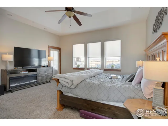 a spacious bedroom with a bed and a flat screen tv