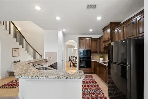 a kitchen with stainless steel appliances granite countertop a refrigerator sink and stove