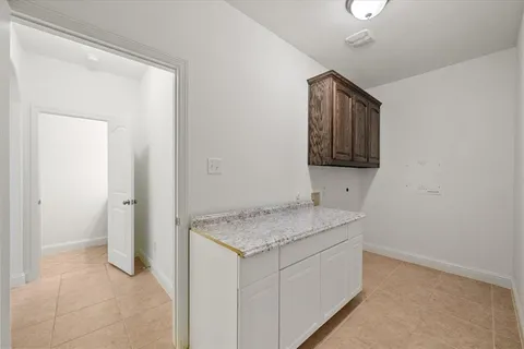 a utility room with a sink a vanity and mirror