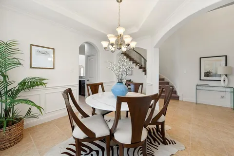 a dining room with furniture potted plants and wooden floor