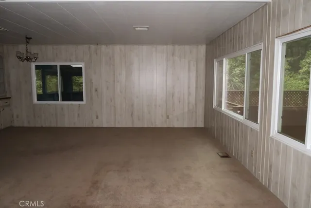 a view of a hallway with wooden shelves and chandelier