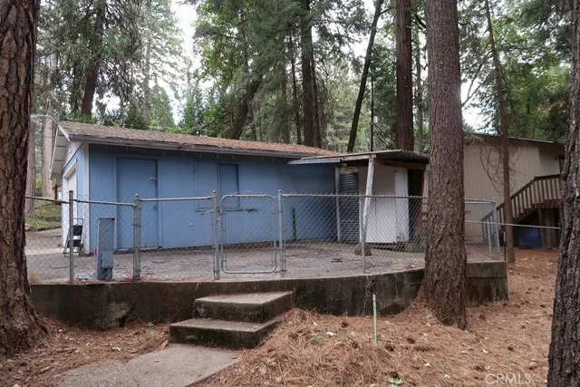 a view of a house with a yard and large tree