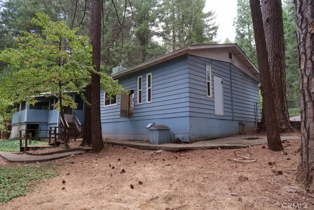 a view of a house with backyard and trees