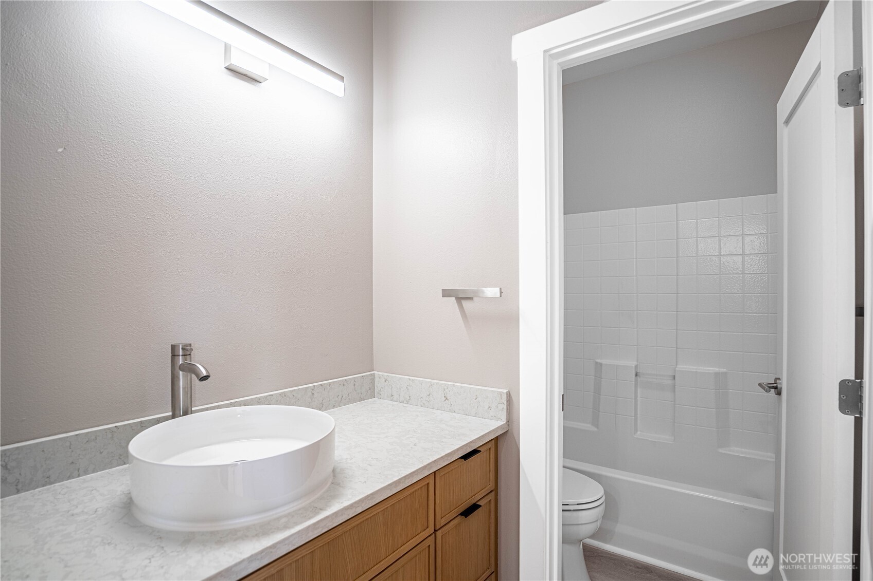 744 Wapato Way, Unit B Manson, WA 98831 - Photo 14 of 32 a bathroom with a granite countertop sink toilet a mirror and shower