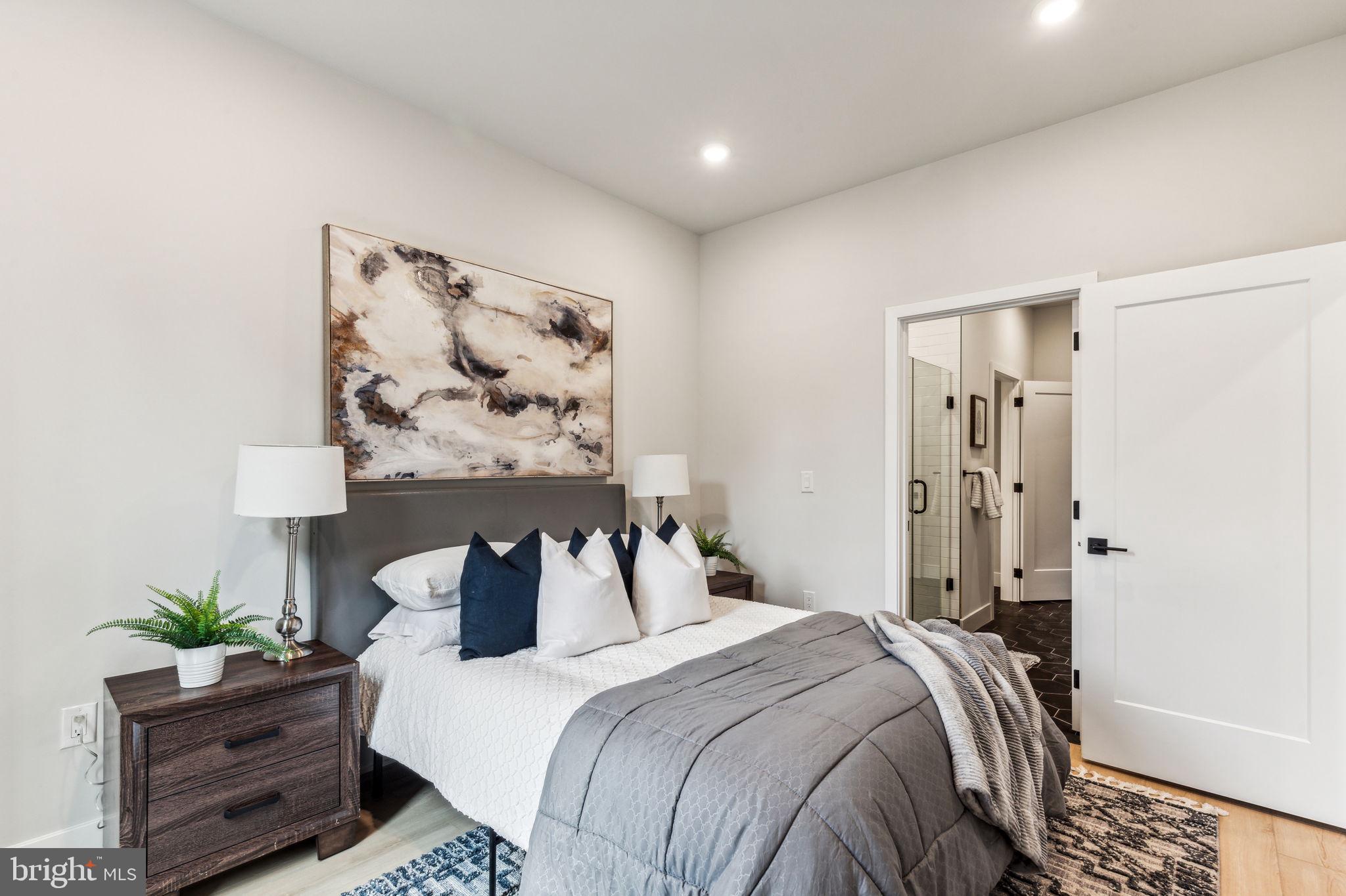 6910 Ridge Avenue, Unit 312 Philadelphia, PA 19128 - Photo 12 of 18 a bedroom with a bed and painting on the wall