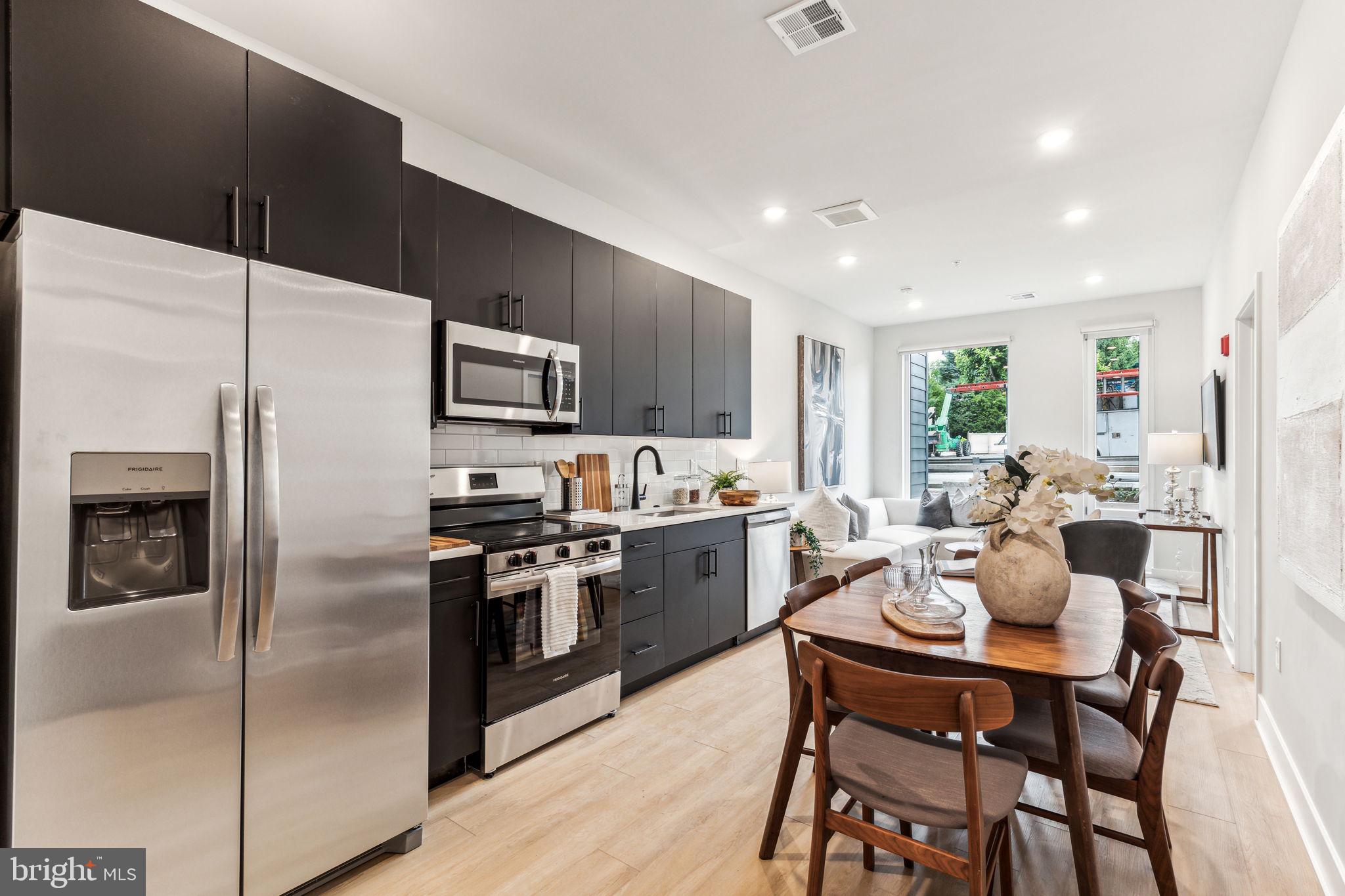 6910 Ridge Avenue, Unit 312 Philadelphia, PA 19128 - Photo 2 of 18 a kitchen with a table chairs refrigerator and microwave
