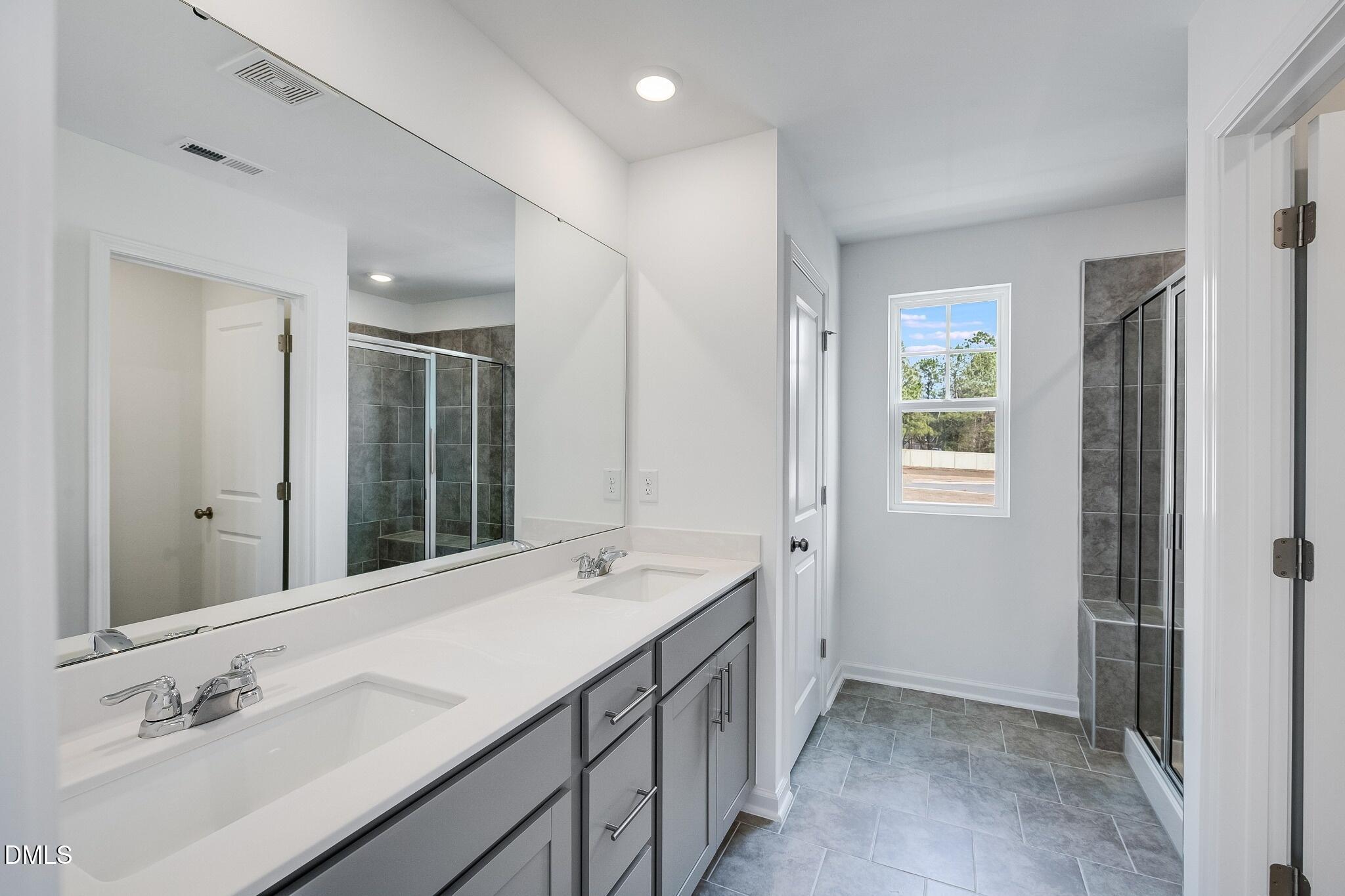 1004 Red Finch Way Angier, NC 27501 - Photo 17 of 42 a bathroom with a double vanity sink mirror and double