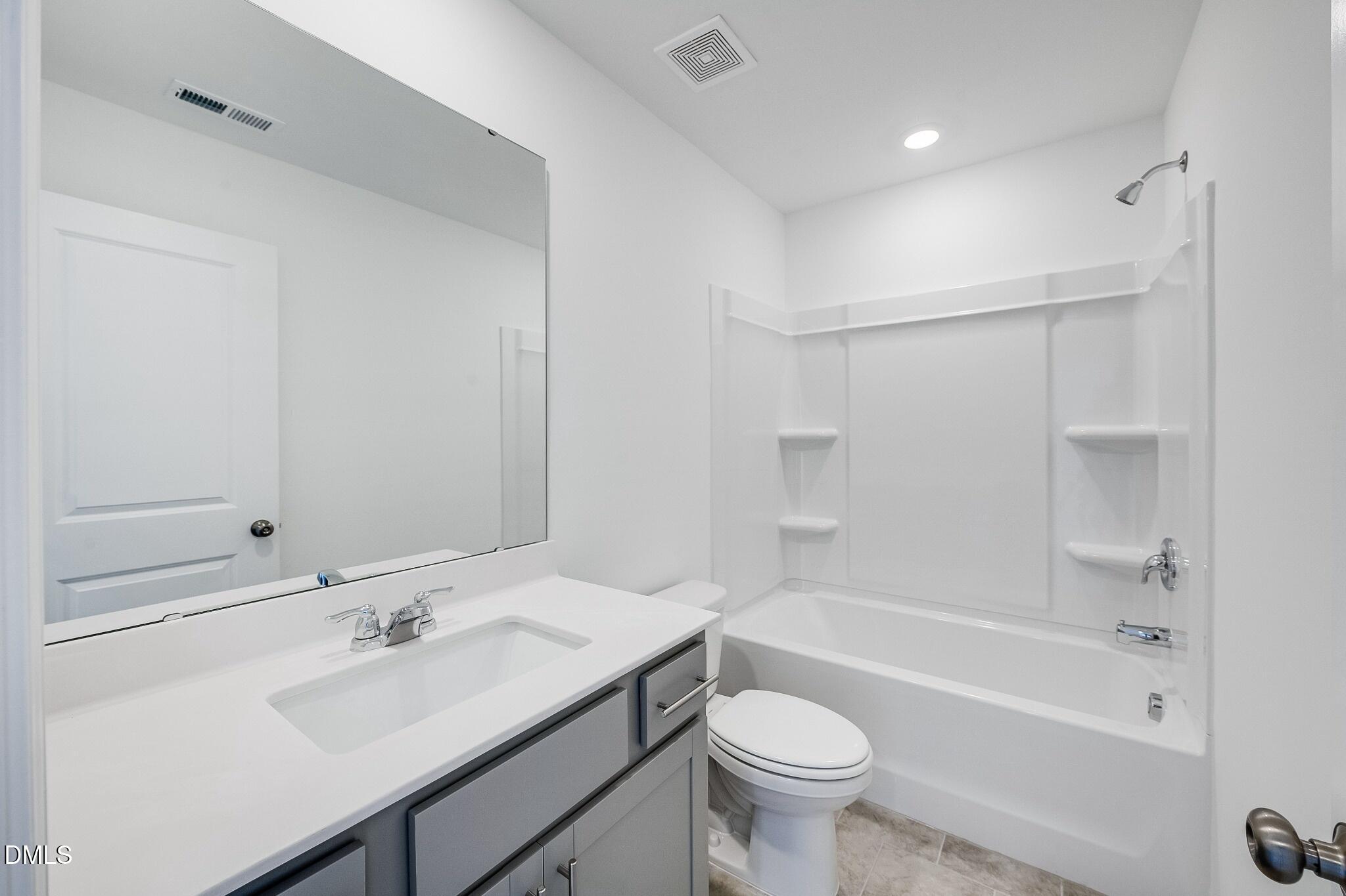 1004 Red Finch Way Angier, NC 27501 - Photo 24 of 42 a bathroom with a sink mirror toilet and bathtub