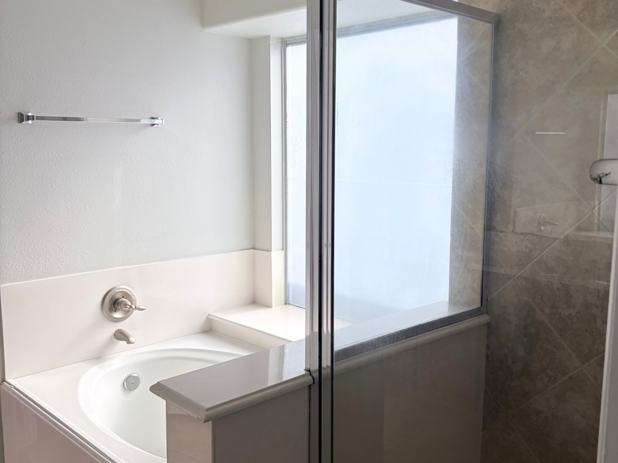 19723 Imperial Colony Lane Katy, TX 77449 - Photo 14 of 16 Relaxing primary ensuite bathroom featuring a soaking tub and separate glass-enclosed shower