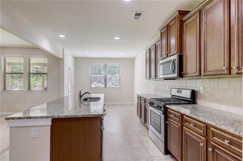 2680 Ogden Trail Buford, GA 30519 - Photo 12 of 45 a kitchen with stainless steel appliances granite countertop a sink stove and cabinets