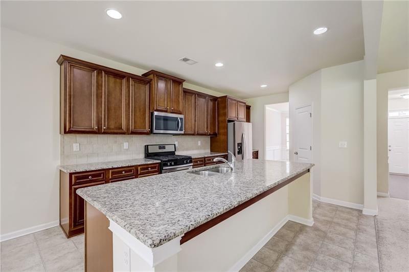 2680 Ogden Trail Buford, GA 30519 - Photo 14 of 45 a kitchen with stainless steel appliances granite countertop a sink a stove and a microwave
