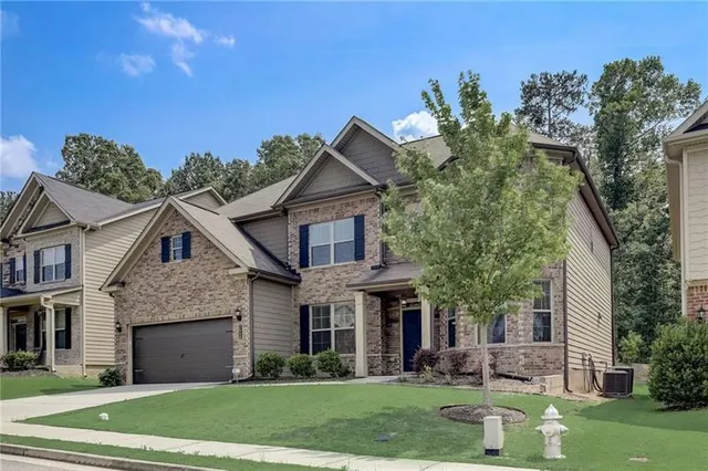 a front view of a house with a yard and trees