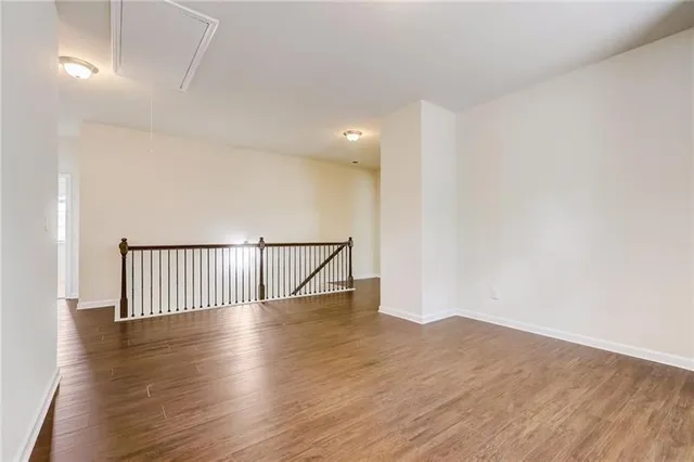 an empty room with windows and ceiling fan