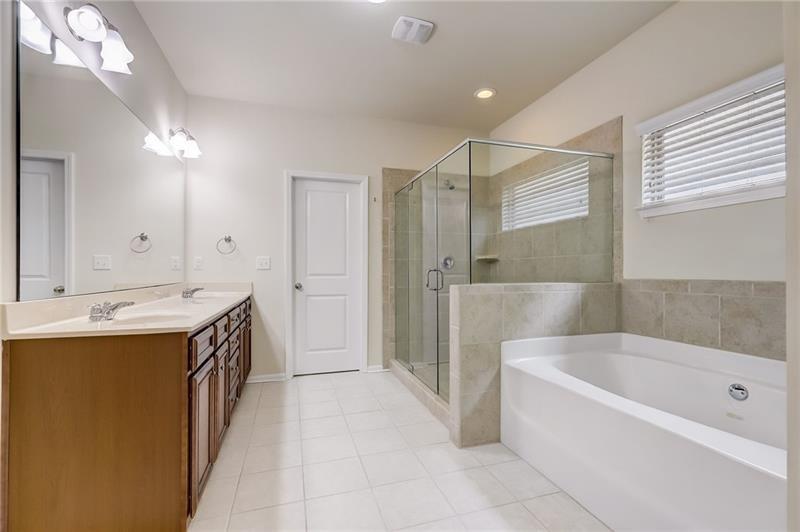 2680 Ogden Trail Buford, GA 30519 - Photo 28 of 45 a spacious bathroom with a tub sink shower and mirror