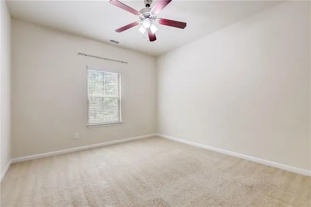 an empty room with chandelier fan
