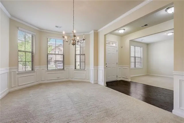 a view of a hallway with wooden floor and chandelier