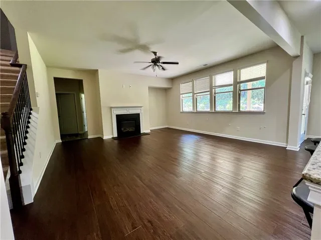 a view of an empty room with chandelier fan and a fireplace