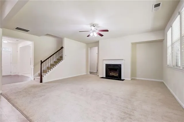 a view of a livingroom with a fireplace and ceiling fan