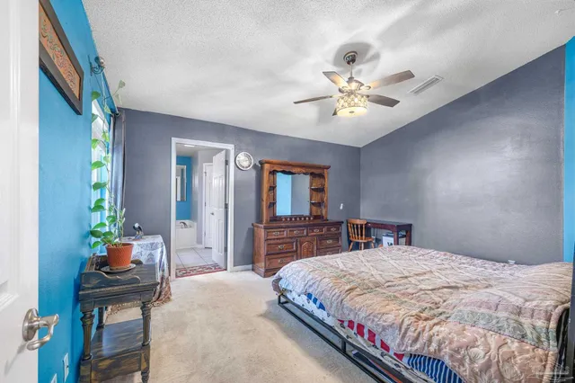 a bedroom with a bed and ceiling fan