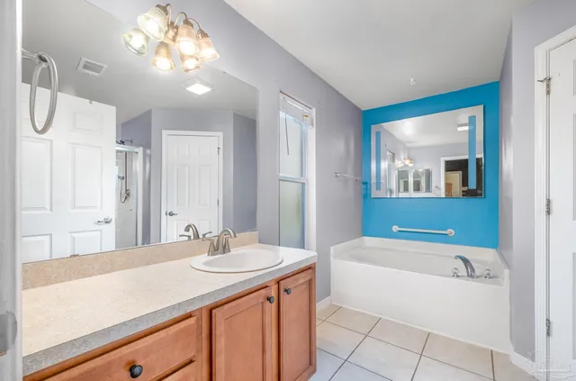 a bathroom with a sink a large mirror and a bathtub