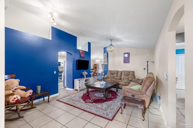 a living room with furniture a flat screen tv and a table