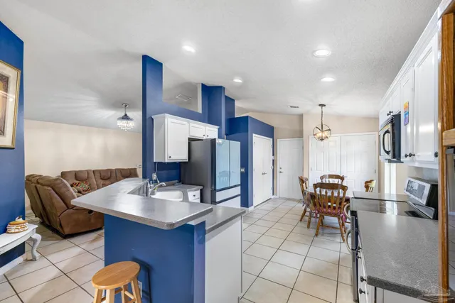 a kitchen with stainless steel appliances kitchen island granite countertop a refrigerator and a stove