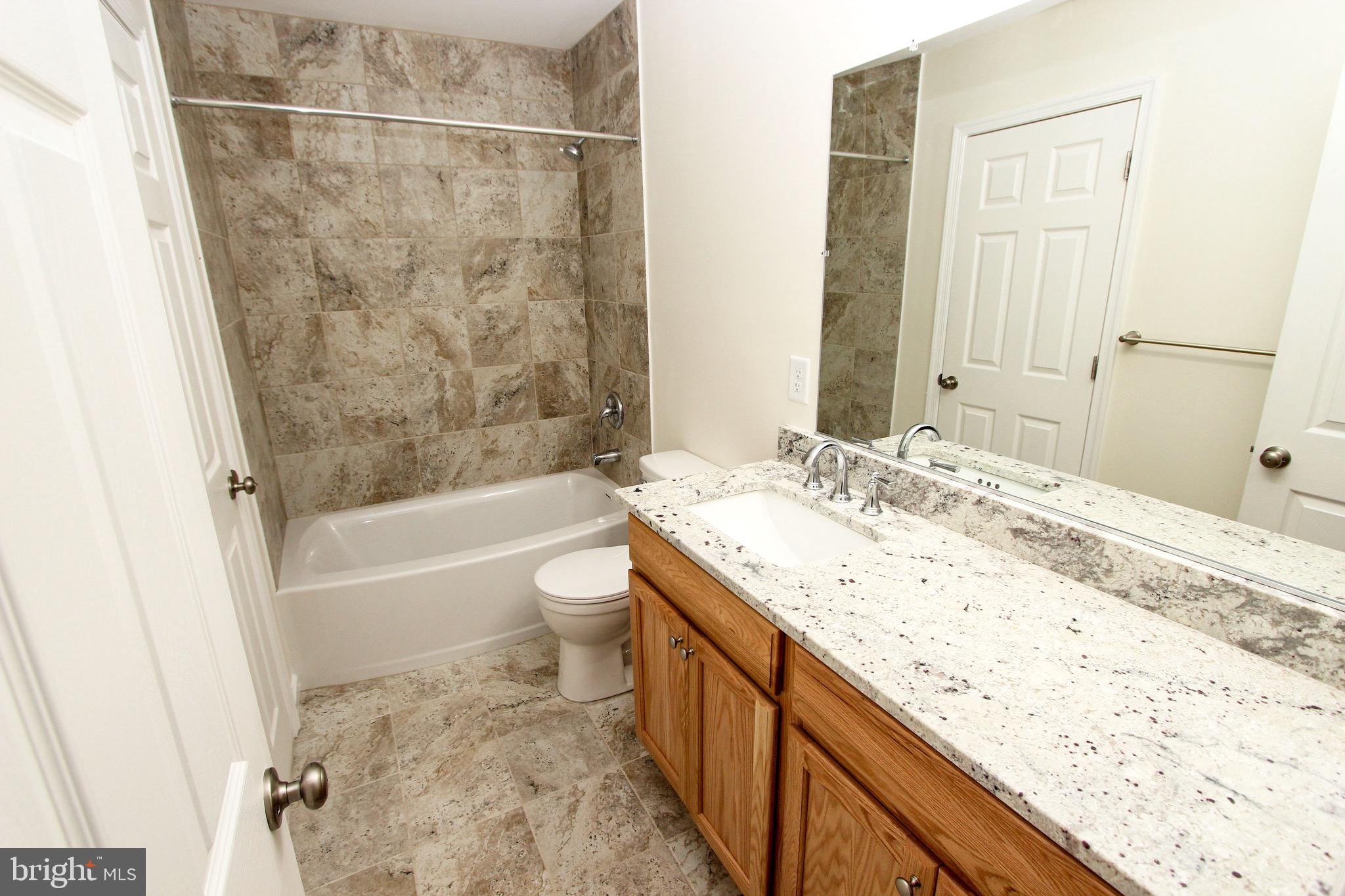 4 Whitetail Way Elkton, MD 21921 - Photo 22 of 28 a bathroom with a granite countertop sink a toilet and bathtub