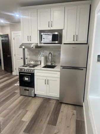 a kitchen with stainless steel appliances granite countertop a refrigerator a stove a sink and a microwave