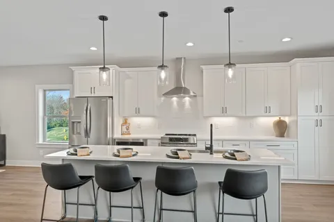 a kitchen with a sink a stove and chairs